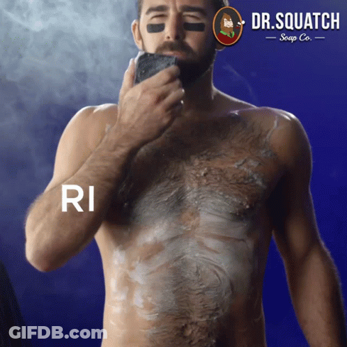 A Shirtless Man Is Shaving His Chest With A Dr. Squatch Soap Co. Logo Behind Him GIF