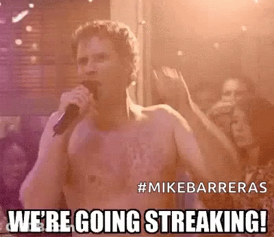 A Shirtless Man Is Singing Into A Microphone In Front Of A Crowd At A Concert . GIF