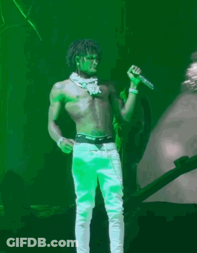 A Shirtless Man Is Singing Into A Microphone With Nike Underwear On GIF
