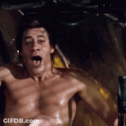 A Shirtless Man Is Sitting In A Bathtub With His Mouth Open And His Tongue Out . GIF