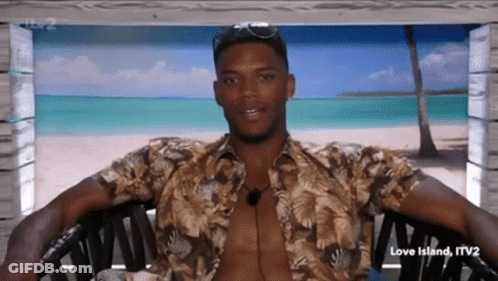A Shirtless Man Is Sitting In A Chair With His Arms Outstretched . GIF