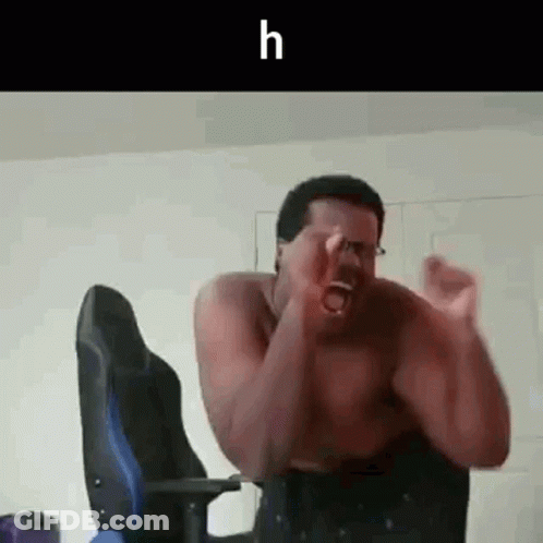 A Shirtless Man Is Sitting In A Chair With His Hands In The Air And Screaming . GIF