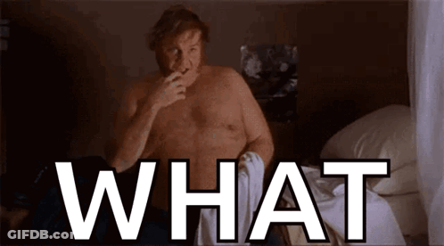 A Shirtless Man Is Sitting On A Bed And Smoking A Cigarette And The Word What Is Above Him . GIF