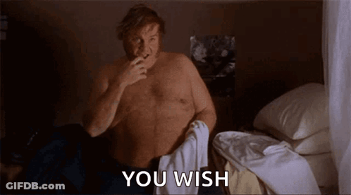 A Shirtless Man Is Sitting On A Bed With A Toothbrush In His Mouth And The Words `` You Wish '' Behind Him . GIF