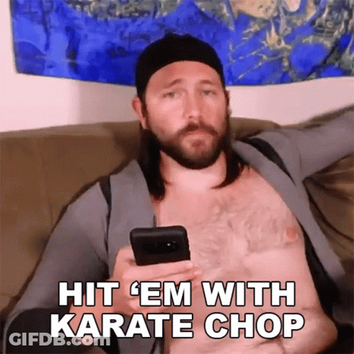 A Shirtless Man Is Sitting On A Couch Holding A Cell Phone With The Words Hit Em With Karate Chop Below Him GIF
