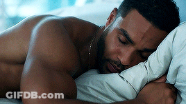 A Shirtless Man Is Sleeping On A Bed With A Pillow . GIF
