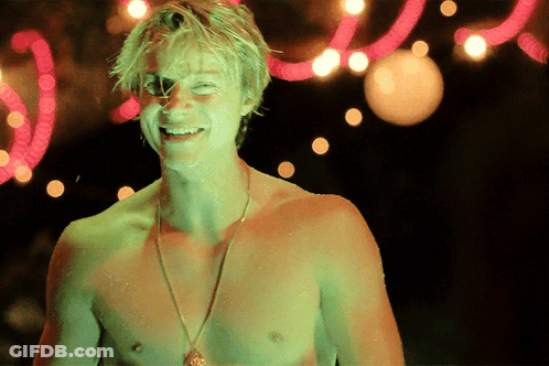 A Shirtless Man Is Smiling In Front Of A Neon Sign That Says ' I Love You ' GIF