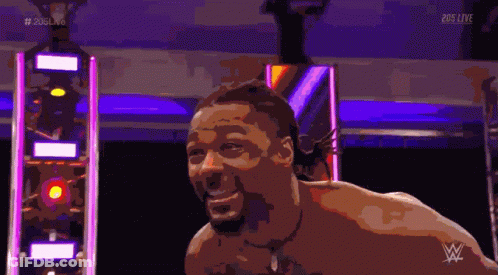A Shirtless Man Is Smiling In Front Of A Sign That Says 205 Live On It GIF