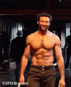 A Shirtless Man Is Smiling While Holding A Knife In His Hand GIF