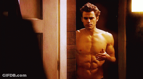 A Shirtless Man Is Standing In A Doorway With His Hands On His Chest GIF
