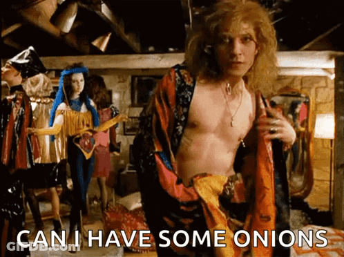 A Shirtless Man Is Standing In A Room With The Words " Can I Have Some Onions " On The Bottom GIF