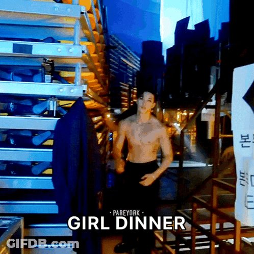 A Shirtless Man Is Standing In A Room With The Words Girl Dinner Written Above Him GIF