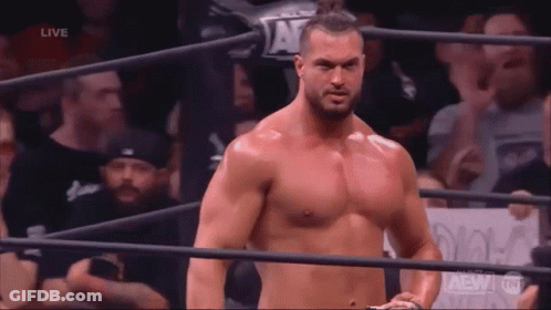 A Shirtless Man Is Standing In A Wrestling Ring . GIF