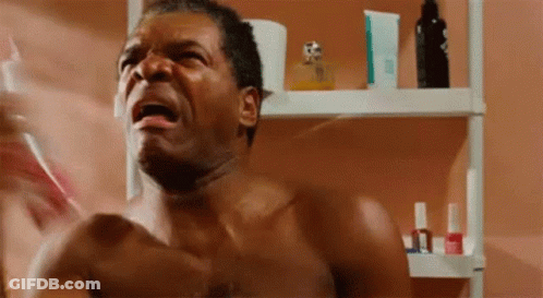 A Shirtless Man Is Standing In Front Of A Bathroom Mirror Holding A Toothbrush . GIF