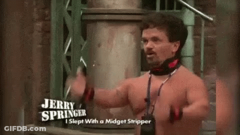 A Shirtless Man Is Standing In Front Of A Building Holding A Sword . GIF