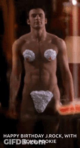A Shirtless Man Is Standing In Front Of A Candle While Wearing A White Underwear . GIF