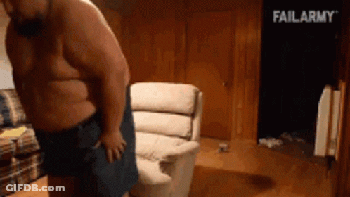 A Shirtless Man Is Standing In Front Of A Couch With Failarmy Written In The Background GIF