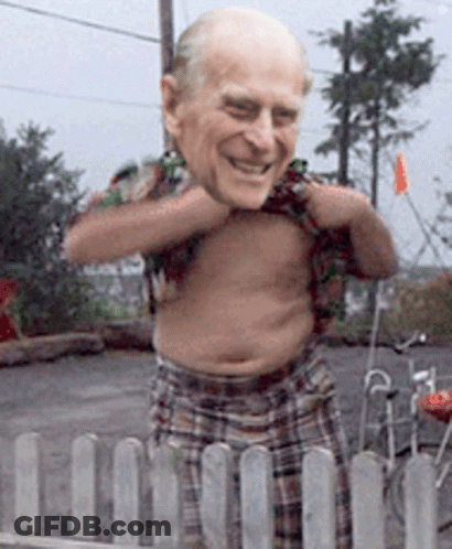 A Shirtless Man Is Standing In Front Of A Fence GIF
