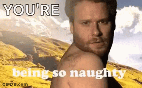 A Shirtless Man Is Standing In Front Of A Mountain With The Words `` You 'Re Being So Naughty '' Written On It . GIF