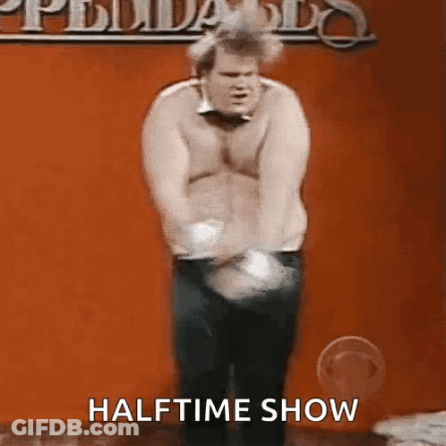 A Shirtless Man Is Standing In Front Of A Red Wall With The Words Halftime Show Written On The Bottom . GIF