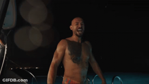 A Shirtless Man Is Standing In Front Of A Sign That Says Edom GIF