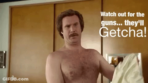 Shirtless Man Standing In Front Of Watch Out For Guns Sign GIF