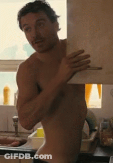 A Shirtless Man Is Standing In Front Of A Sink Holding A Piece Of Paper GIF