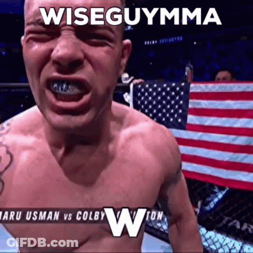 A Shirtless Man Is Standing In Front Of An American Flag With The Caption Wiseguymma GIF