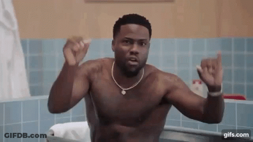 A Shirtless Man Is Taking A Bath In A Bathtub And Making A Funny Face . GIF