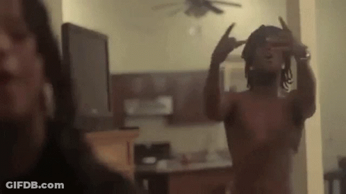 A Shirtless Man Is Taking A Picture Of Himself In A Mirror In A Living Room . GIF