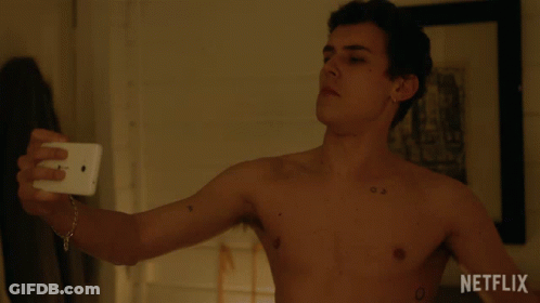 A Shirtless Man Is Taking A Selfie With A Netflix Logo In The Background GIF