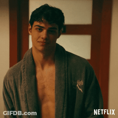 A Shirtless Man Is Wearing A Robe With The Word High Embroidered On It GIF