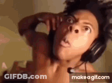 A Shirtless Man Is Wearing Headphones And Making A Face . GIF