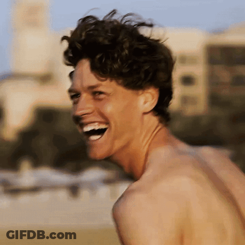 A Shirtless Man Laughs With His Mouth Open GIF