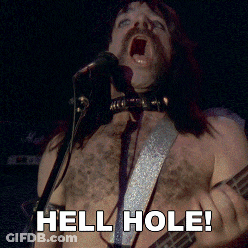 A Shirtless Man Singing Into A Microphone And Playing A Guitar With The Words Hell Hole Below Him GIF