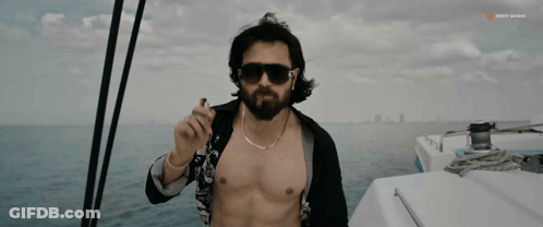 A Shirtless Man Smoking A Cigarette On A Boat With Sunny Music Written On The Bottom GIF