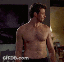 A Shirtless Man Standing In A Living Room GIF