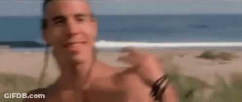 A Shirtless Man Standing On A Beach With The Words That Would Above Him GIF