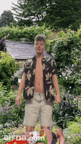 A Shirtless Man Stands In A Garden With Flowers GIF