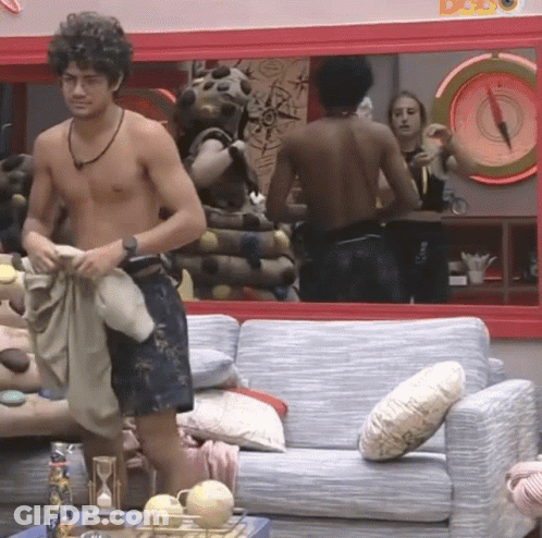 Shirtless Man Standing In Front Of Couch And Mirror GIF