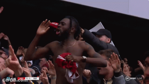 A Shirtless Man Stands In Front Of A Crowd At A Soccer Game GIF