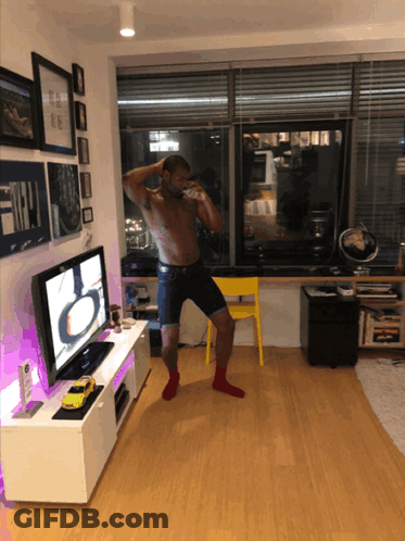 A Shirtless Man Stands In Front Of A Samsung Flat Screen Tv GIF