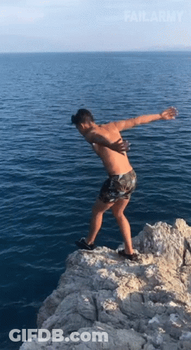 A Shirtless Man Stands On A Rocky Cliff Overlooking The Ocean With Failarmy Written On The Bottom GIF
