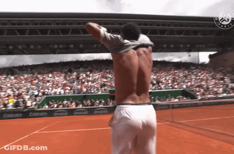 A Shirtless Man Stands On A Tennis Court In Front Of A Crowd And A Coca Cola Banner GIF