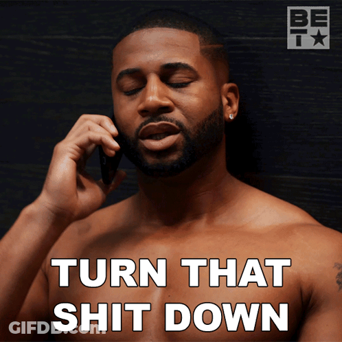 A Shirtless Man Talking On A Cell Phone With The Words Turn That Shit Down GIF