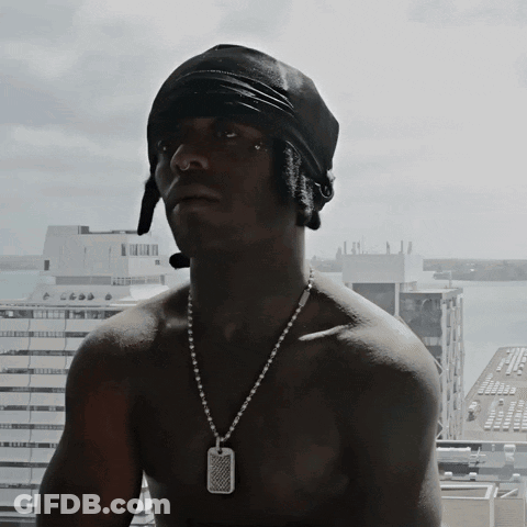 A Shirtless Man Wearing A Black Bandana And A Necklace With A Dog Tag On It GIF