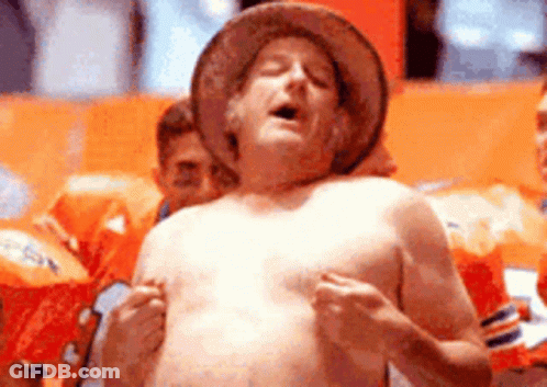 A Shirtless Man Wearing A Cowboy Hat Is Standing In A Crowd GIF