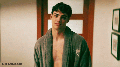 A Shirtless Man Wearing A Grey Robe With A Puma Logo On His Chest GIF