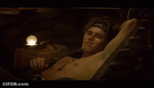 A Shirtless Man Wearing A Headband With The Word Warrior On It Waves His Hand GIF