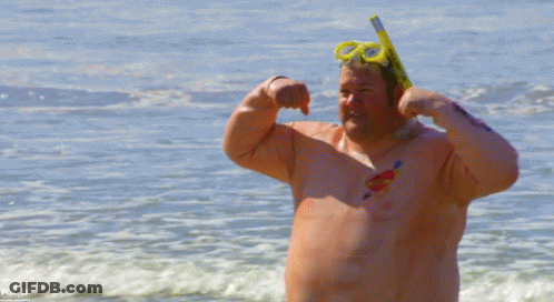 A Shirtless Man Wearing A Snorkel And Goggles Flexes His Muscles On A Beach GIF